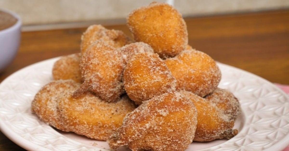Prato com bolinhos de chuva redondinhos e bem fofinhos cobertos com açúcar e canela