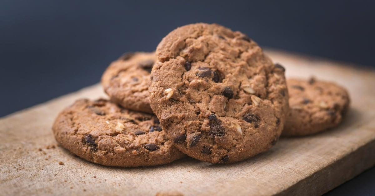 Cookies americanos artesanais dourados com chocolate derretido e gotas brilhantes em assadeira rústica