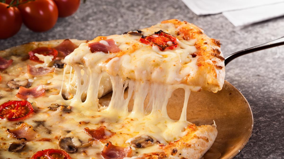 Massa de pizza fresca artesanal aberta com molho de tomate rústico e bordas douradas crocantes